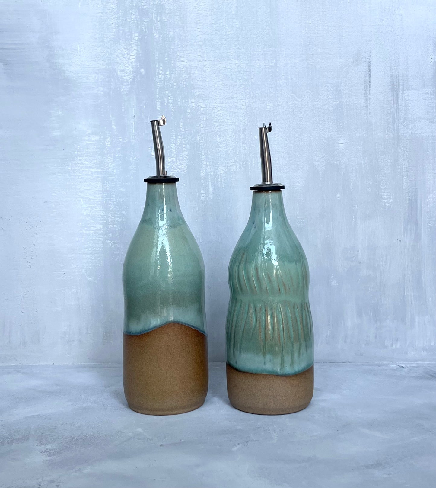 Juego de dos botellas de aceite de oliva turquesa y arena